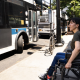 Woman in a wheelchair waiting at a bus stop